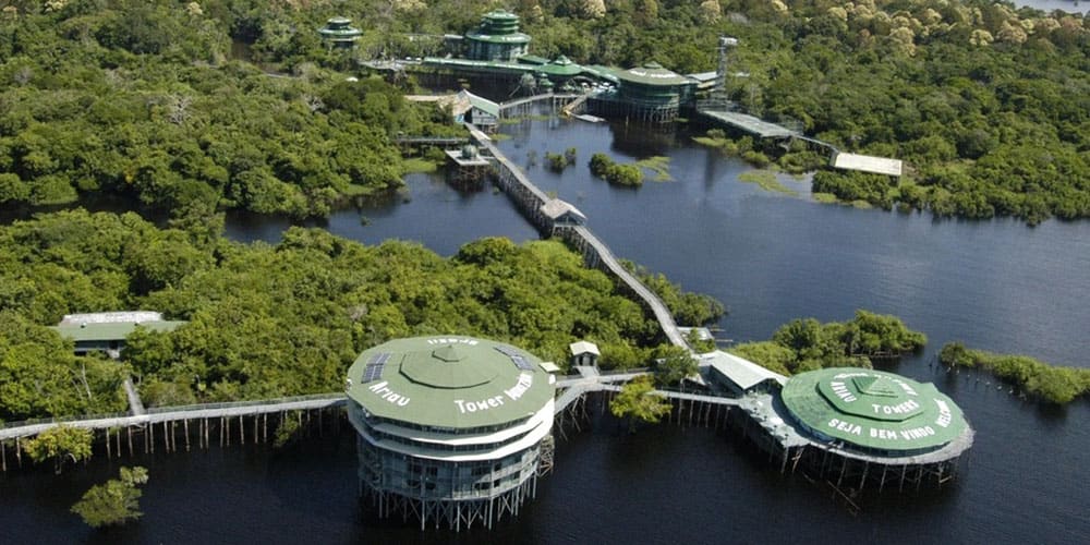 Vue aérienne spectaculaire de l’hôtel Ariaú Amazon Towers, un complexe touristique construit sur pilotis au cœur de la forêt amazonienne, au bord du Rio Negro.