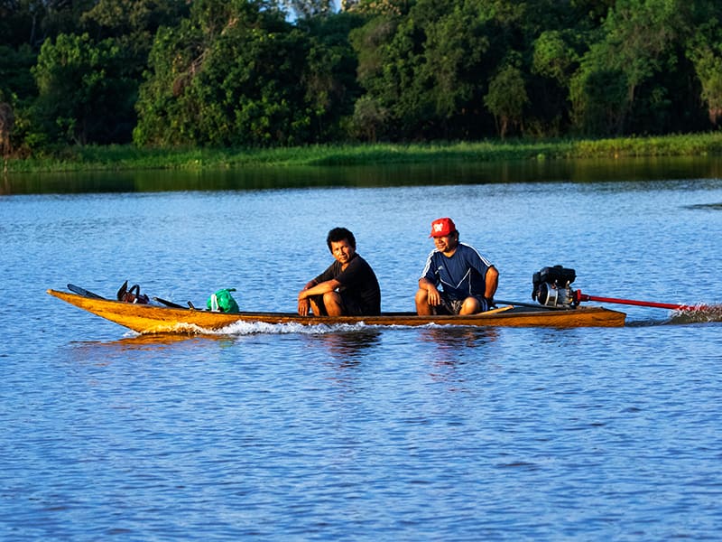 Deux caboclos naviguant en canoë sur une rivière en Amazonie