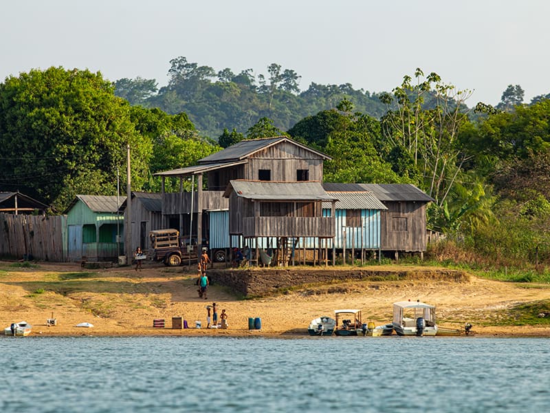 Village riverain en Amazonie avec des maisons sur pilotis en bois