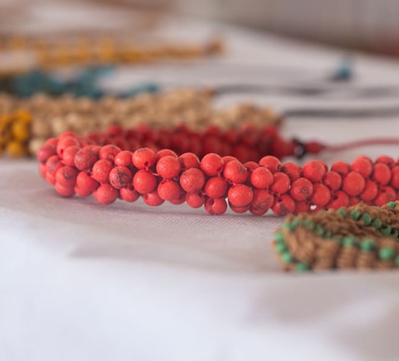 Collier artisanal en graines rouges d'Amazonie, mis en valeur sur une table blanche