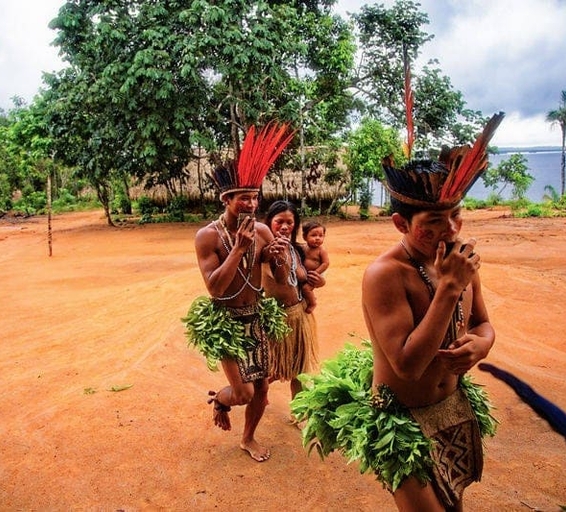 Un petit groupe d’hommes et de femmes autochtones pendant une danse traditionnelle